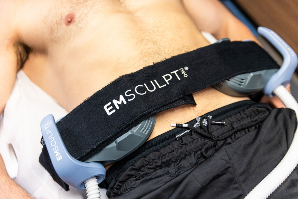 A close-up of a patient at Spa 29 improving both the muscle tone and stubborn fat on their abdomen using Emsculpt NEO near St. Simons Island, GA.