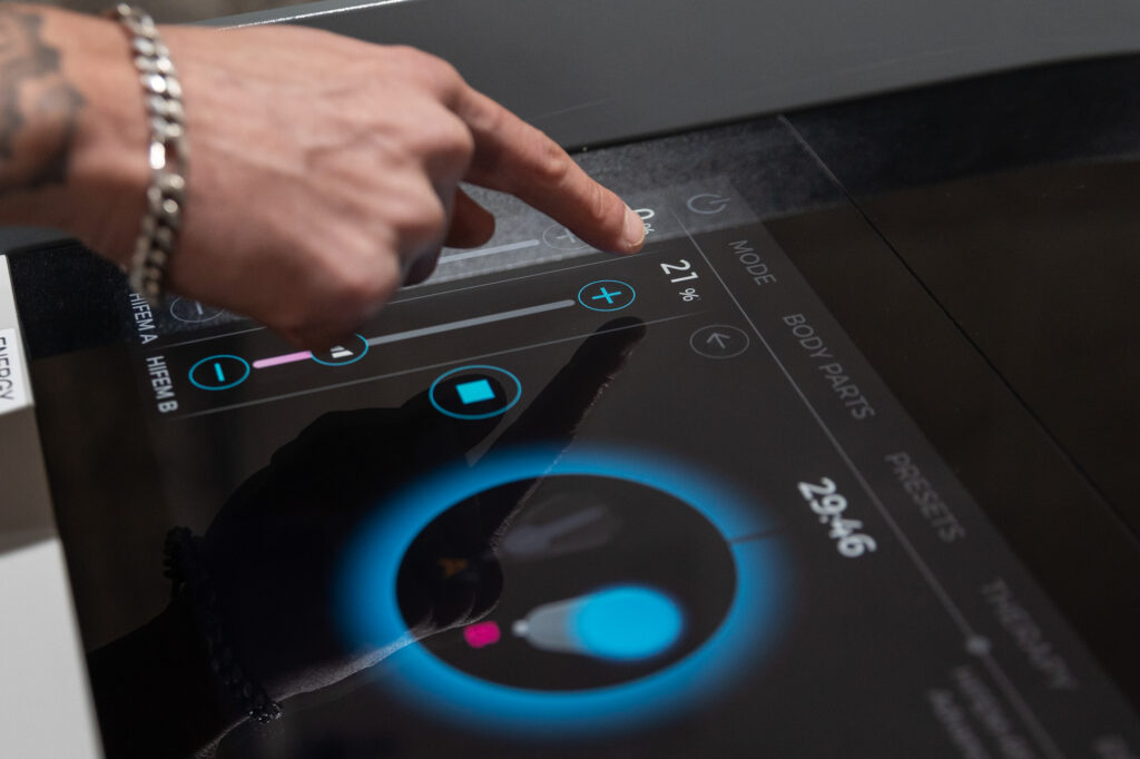 A close-up of a provider at Spa 29 using the touch screen controls to adjust the treatment of Emsculpt NEO near St. Simons Island, GA.